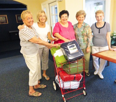 Diane Naples (center) along with her friends (from left to right) Annette Hanisch, Arlene Gwozdz, Irm Niemann, and Phyllis Nevem are eager to see how many blankets have been donated already. Their goal is to raise 500 new blankets by September 30, 2010 to donate to people in need at St. Mary’s Church in Huntley, IL. (Photo by Alissa Leznek)
