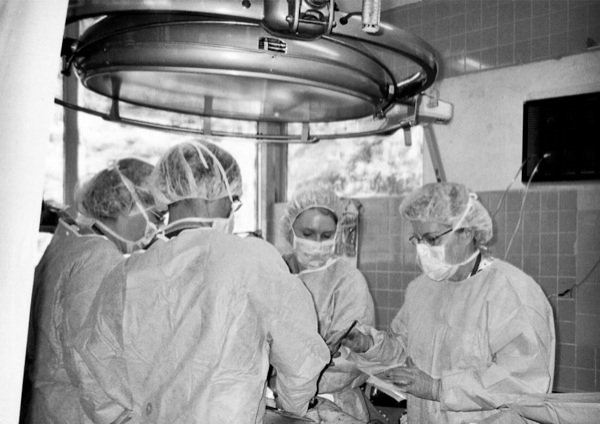 Esau (bottom right) assists doctors operating on a Dominican Republic local at a previous mission. (Photo provided)