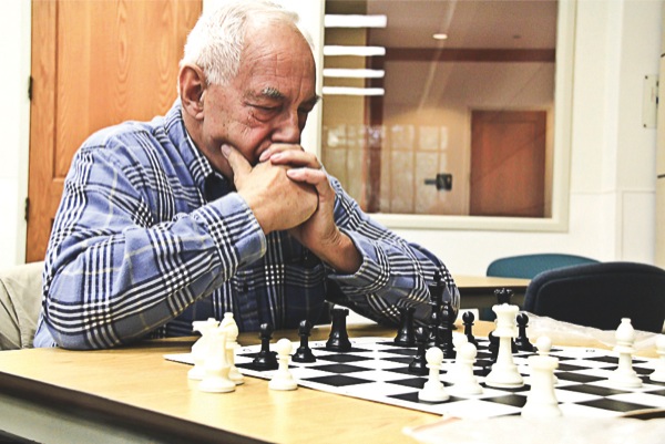 Chess Club members Bob Kries (above) and Bill Macomber (below) focus on their next moves. (Photos by Hannah Sturtecky/Sun Day)