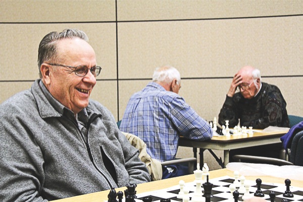 Chess Club vice president Wayne Simons (left) laughs over a joke his opponent made while Bob Kries (middle) and his opponent Bill Macomber (right) focus on their game. (Photo by Hannah Sturtecky/Sun Day)