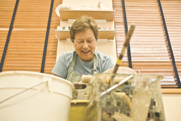 Neighborhood 11 resident spins a vase on a pottery wheel in the clayground workshop. (Photo by Chris LaPelusa/Sun Day)
