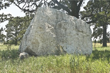 This boulder sits on the lot of a proposed retail project by Interstate Partners. The origins of the rock are unknown, as are the plans for its future if the project is approved. (Photo by Mason Souza/Sun Day)
