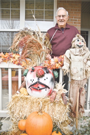 Sun City resident Joe Nitti admires the pumpkin face he created for the holiday, which stems from a long-standing tradition he learned as a youth working for Tom Naples Vegetable Market in Chicago. (Photo by Chris LaPelusa/Sun Day)