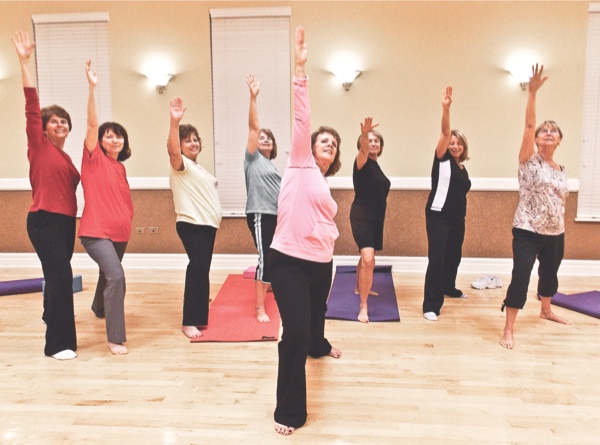 Nancy Heart (front) leads her Yoga From the Heart students in the reverse warrior pose to build confidence and strength. (Photo by Glynn Wade/Sun Day)