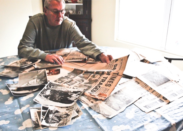 Richard Holman looks over his newspaper clippings and photos documenting the fire at Our Lady of the Angels in 1958. Holman, then a photographer for the Northwest Times in Chicago, also had experiences meeting President John F. Kennedy and Soviet Premier Nikita Khruschev. (Photo by Hannah Sturtecky/Sun Day)