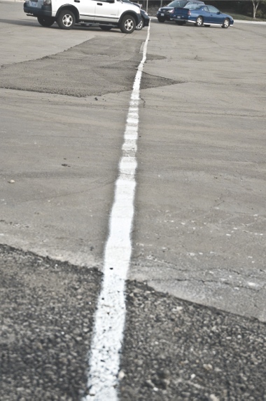 Cars park along a temporary line in the parking lot in front of Prairie Lodge. Plans for the parking lot include changing diagonal spaces in front of Jameson’s and Whisper Creek’s pro shop to perpendicular spaces to create more room. (Photo by Chris LaPelusa/Sun Day)