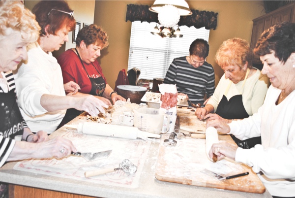 The family of bakers (left to right: Rosemary Orlando, Denyse Thillen, Carol Bonafede, Judy Bonafede, Marge Hammersmith, and Sharon Leibach) work on an assembly line to make Cucidati, a traditional Italian cookie. (Photo by Rebecca Vasquez/Sun Day)