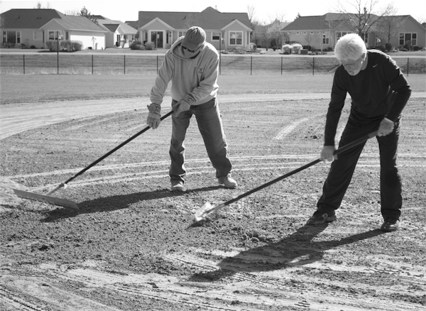Steve Kutska and Terry Johnson rake the infield. (Photo by Victoria Diamond/Sun Day)