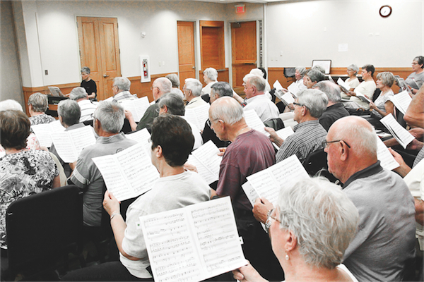 Prairie Singers rehearse in Fountain View. The group reads sheet music for the song ‘Route 66,’ one of the pieces they plan on singing at the concert. (Photo by Hannah Sturtecky/Sun Day)