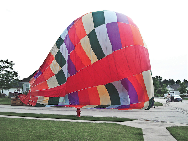 Hot air balloon lands on intersection of Windy Prairie Dr. and Songbird Ln. in Neighborhood 32B. Emergency or not? (Photo provided by Tom Sansom)