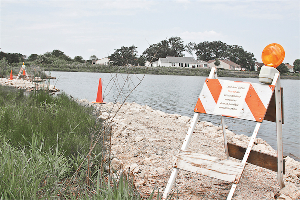 Warning signs posted around Wildflower lake advise residents the lake is closed for precautionary measures. (Photo by Chris LaPelusa/Sun Day)