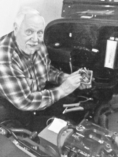 John Jeide is featured here working on the bumper hitch of one of his transformed electric cars. (Photo provided)