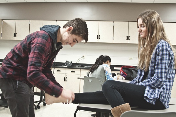 Junior Eric Maurer tapes senior Brooke Schlotman’s ankle for a demonstration in HHS’s sports medicine class.