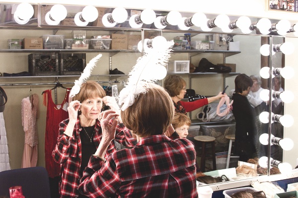 Mary Wyatt secures a feather to her wig. 