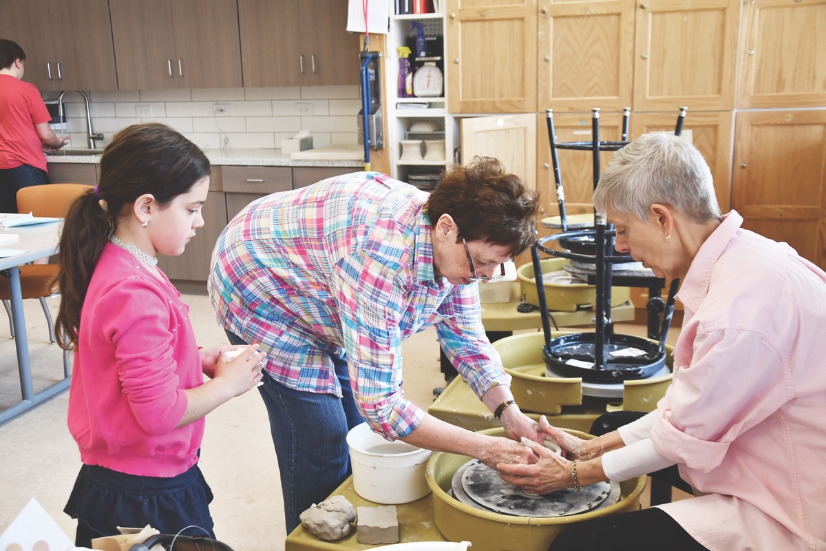 Grandma’s turn at the wheel. Cathleen Chay (right) helps instruct GGM member and her granddaughter at the spinning wheel. (Photos by Christine Such/Sun Day)