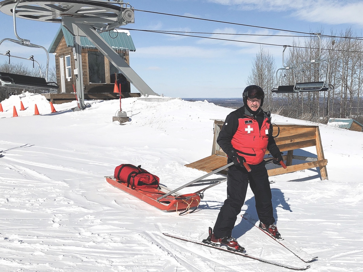 Alex Schank with the toboggan that delivers the injured down the mountain safely. (Photo provided)