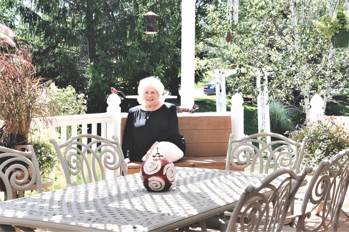 The humorous Jacque Stashwick enjoys the view of her ‘magic farm’ from the lovely patio her husband built. (Photo by Christine Such/Sun Day)