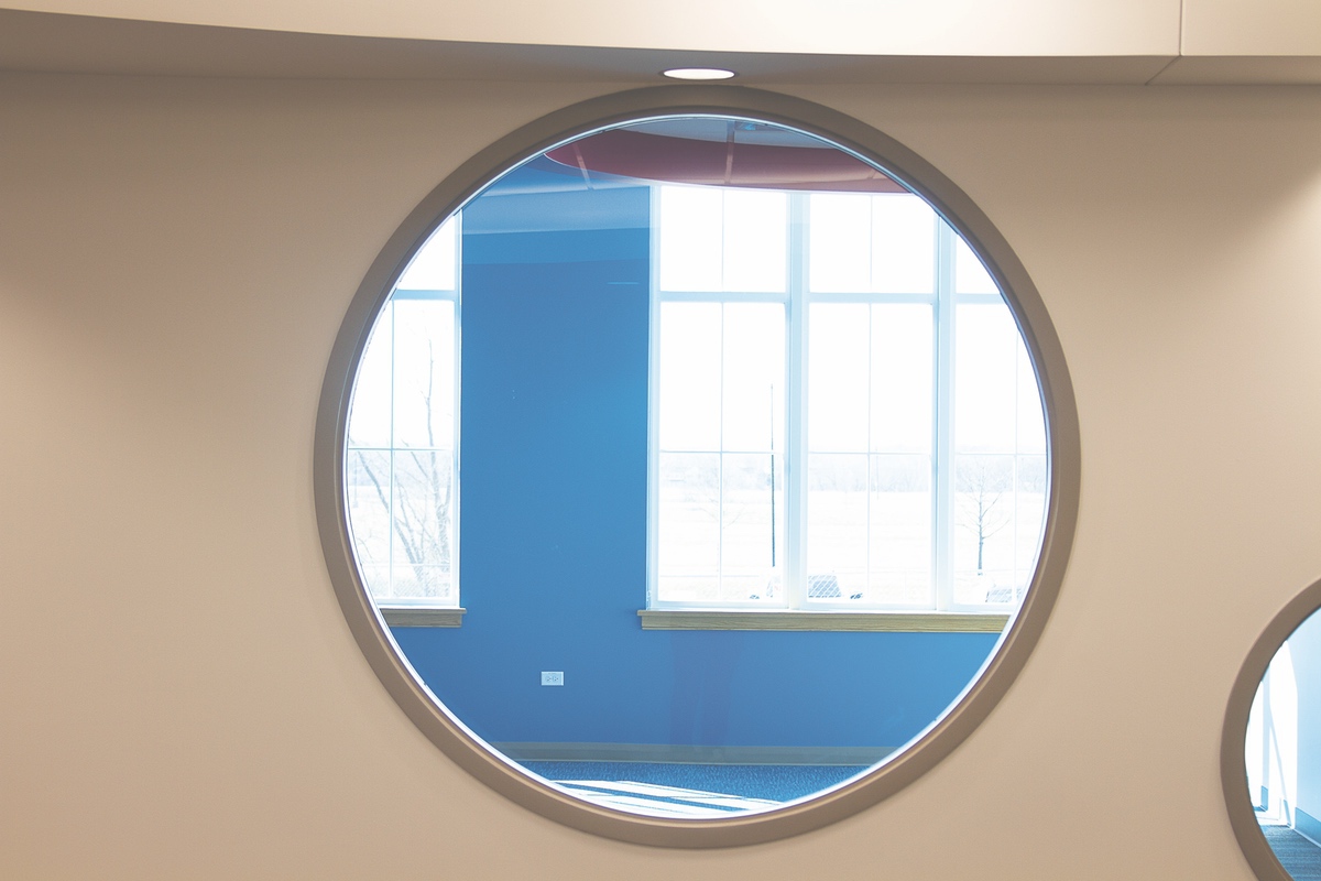 A wall of circular windows that accent the children’s room.