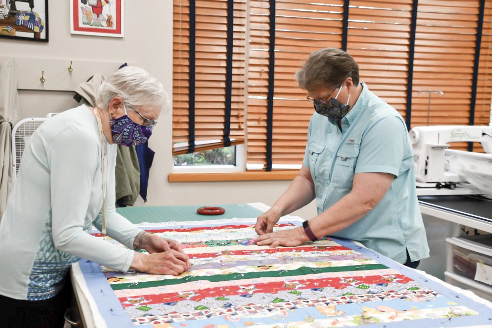Betty Casey (L) and Jane Budzynski working on a quilt. (Photo by Christine Such/Sun Day)