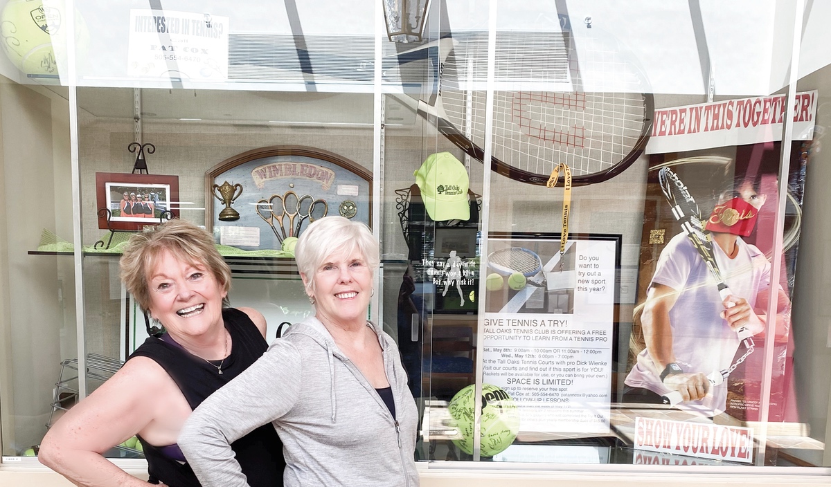 Tennis CLub members Diane Flanagan (L) and Peggy Kennedy with their display case. (Photo by Christine Such/Sun Day)