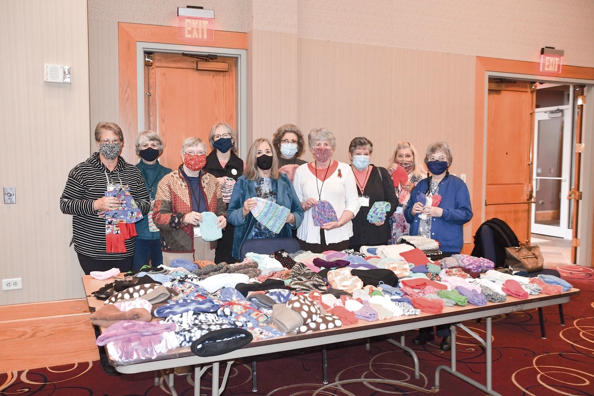 Harriet Ford (center, blue jacket) with the Grafton Food Pantry, accepts the warm donation made by Sew N Sews club membership. (Photo by Christine Such/My Sun Day News)