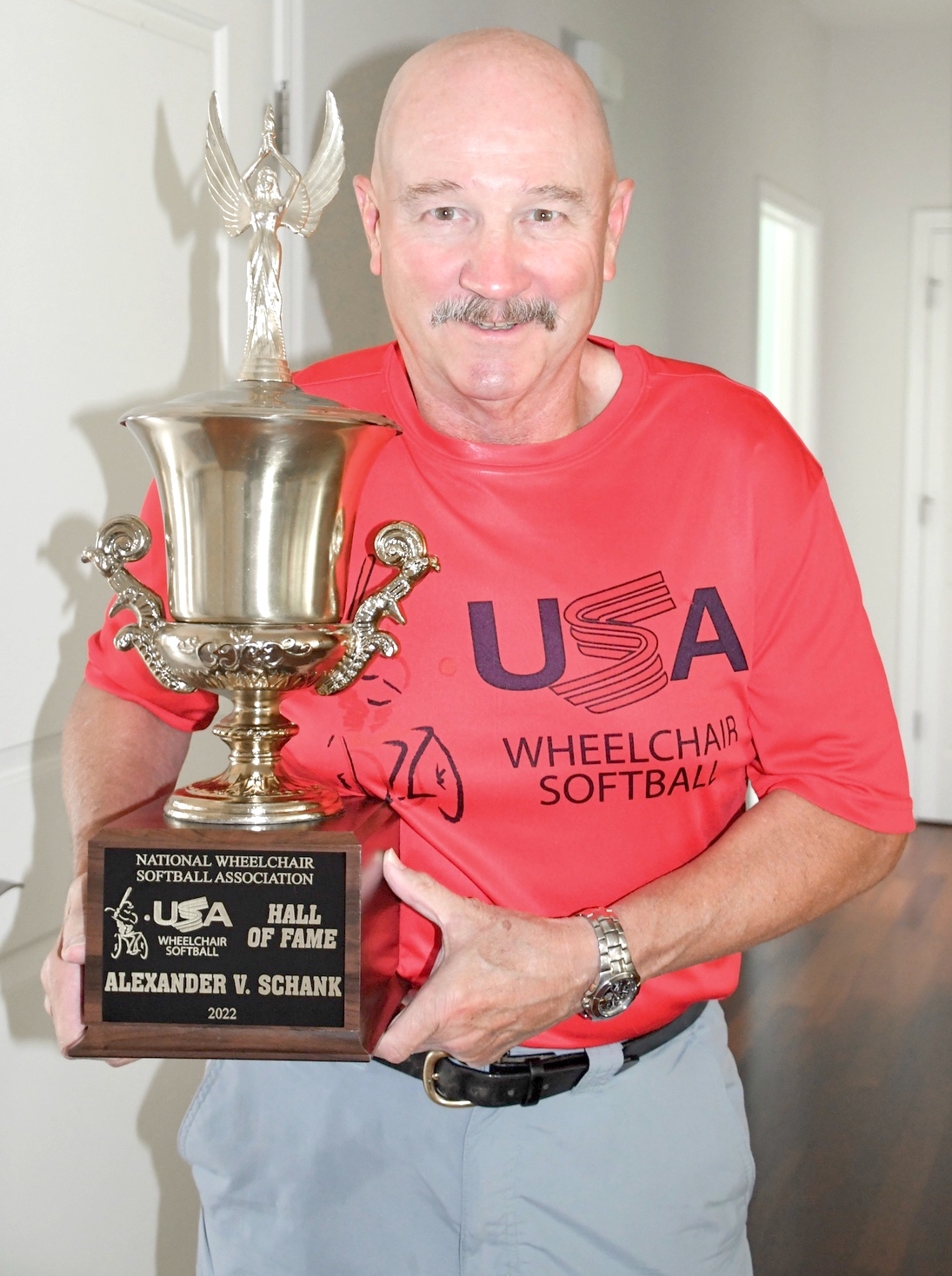 Alex Schank holds his trophy given to him for His Umpiring in the National Wheelchair Softball Association. (Photo by Christine Such/My Sun Day News)