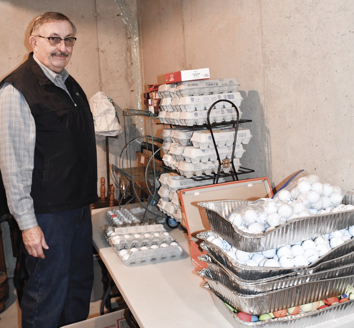 Jim Moellendorf sorts collected golf balls and packages them in egg cartons. He then sells the golf balls and donates 100% of the proceeds to the Grafton Food Pantry. In 2022, he donated approx. $3,000. (Photo by Christine Such/My Sun Day News)