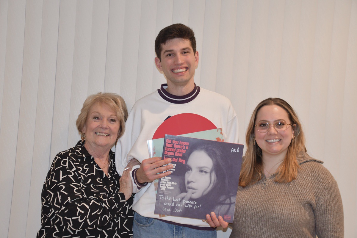 (Left) Diane Flanagan, with Josh ‘AK’ Konstanty, and and her granddaughter Erin Flanagan holding a special version of a red Vinyl Lana del Rey Album that features music composed by Konstanty. (Photo by Christine Such/My Sun Day News)