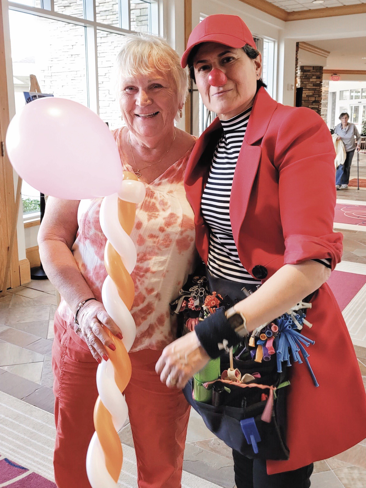 Melissa Gonzales, peforming as Gonzo, presents Sun City resident Mary Honeman with a balloon scepter. (Photo by Christine Such/My Sun Day News)