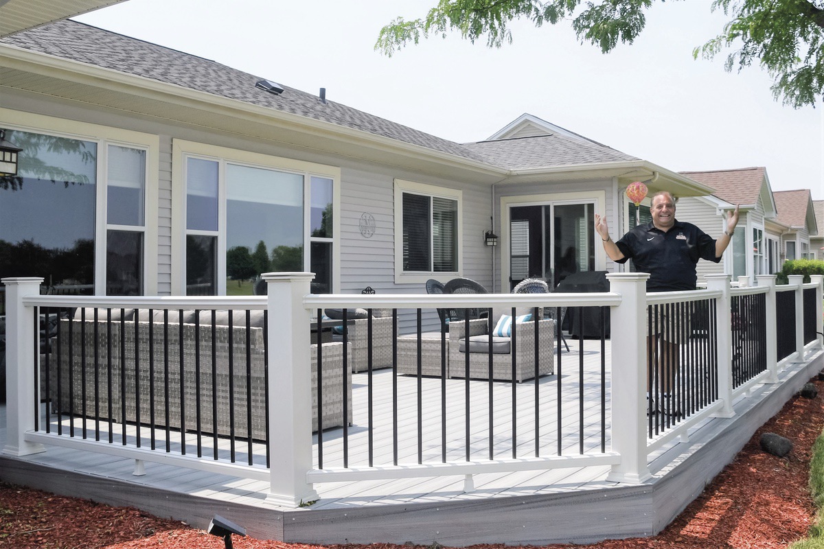 Sun City resident Peter Norton stands on his newly renovated deck, which community management states is in violation of bylaws due to the black balusters.(Photo by Christine Such/My Sun Day News)