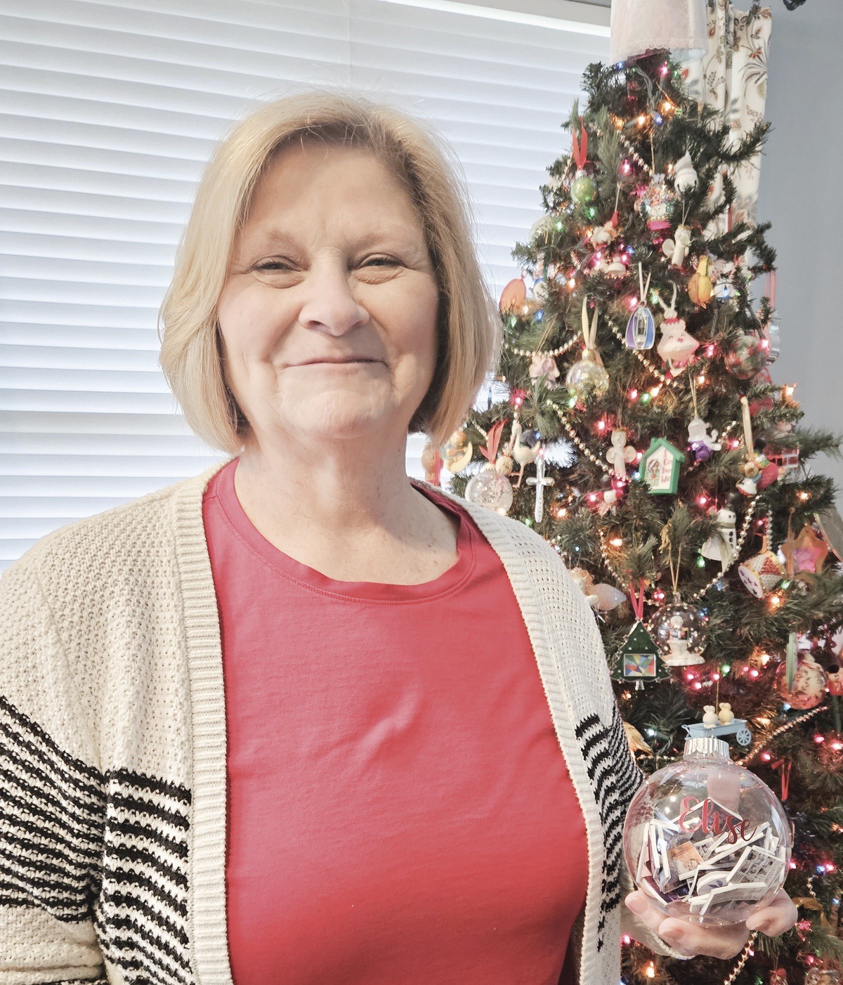 Nedra Reeves holds a keepsake for her granddaughter, Elise, an ornament containing 50 photos of her role in Sun City’s productions of The Sound of Music.