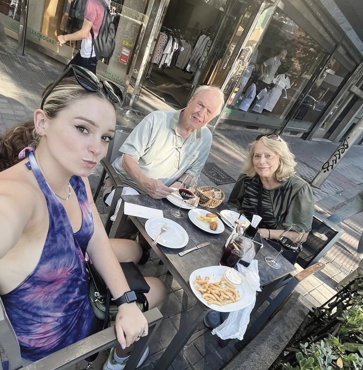 Mike and Eileen Giltner join their granddaughter, Daphne, who attends college in Madrid, for a meal along a sidewalk. (Photo provided)