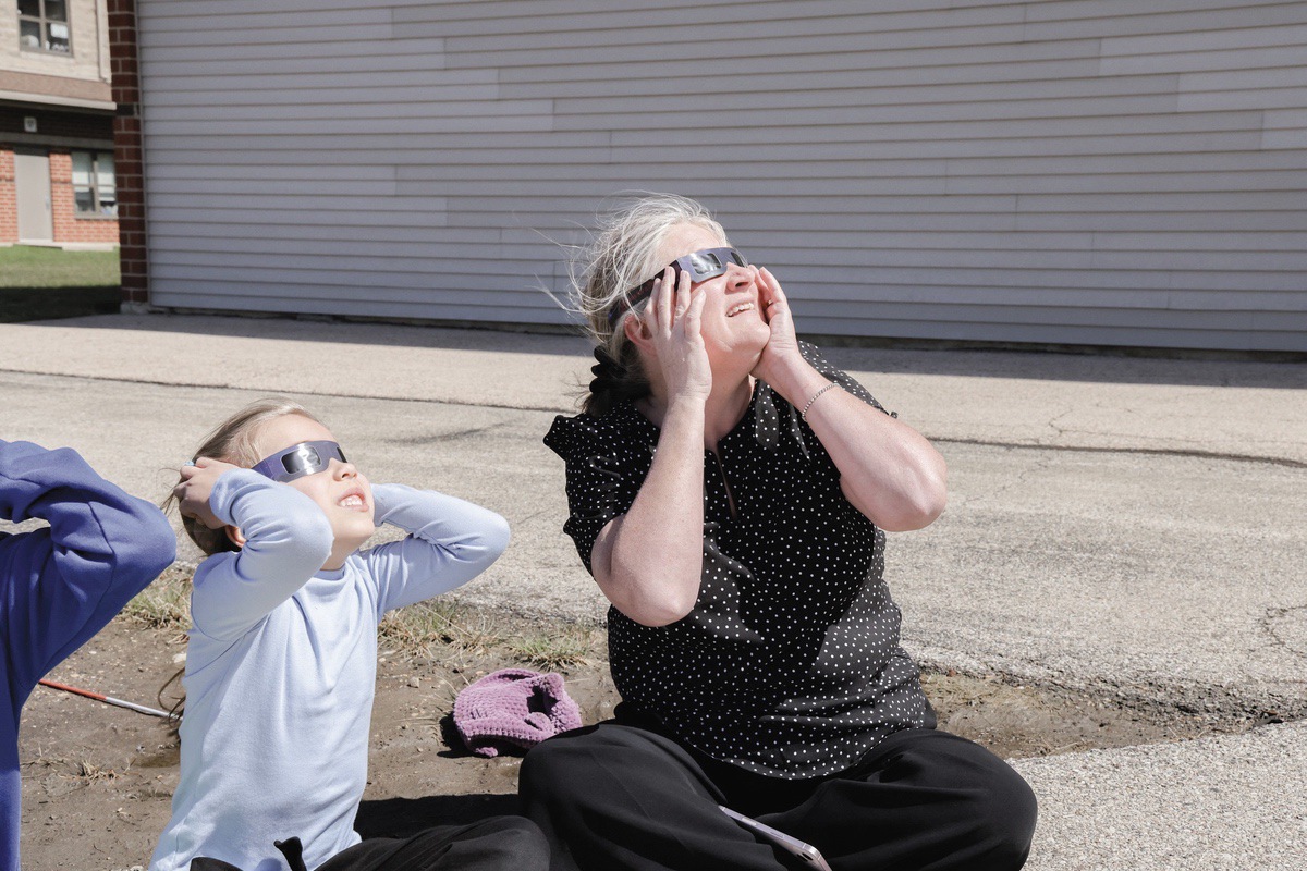 A D158 student views the eclipse with Superintendent Jessica Lombard. (Photo provided)