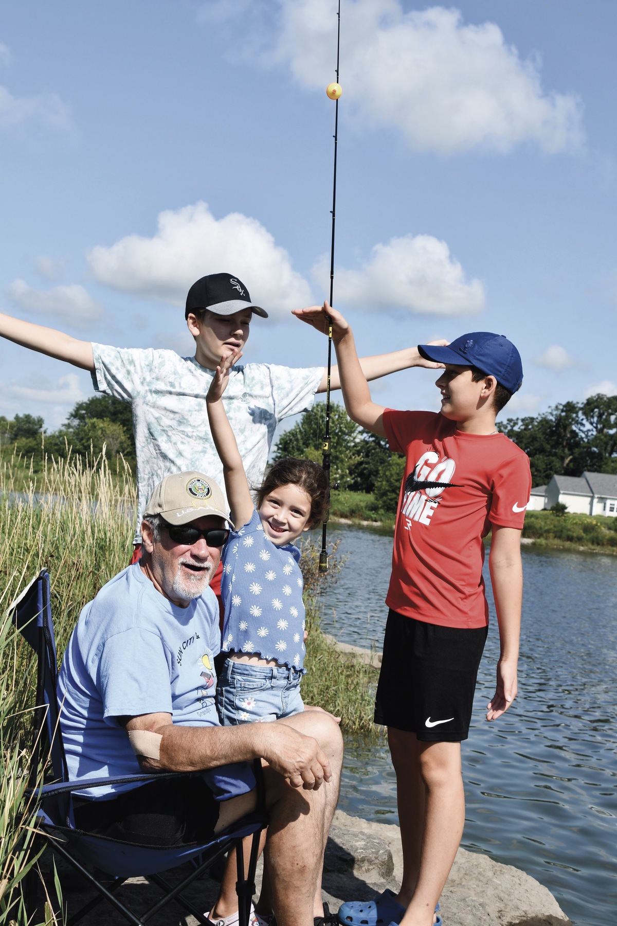 Ken Such with grandkids Lucy, Harrison, and Weston illustrating how big their catch was.