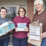 Grafton Food Pantry volunteer Rich Ford delivers a donation bag to Sun City resident Stacey Sadowski and her daughter Amanda, who have already been shopping for Stamp Out Hunger. (Photo provided)