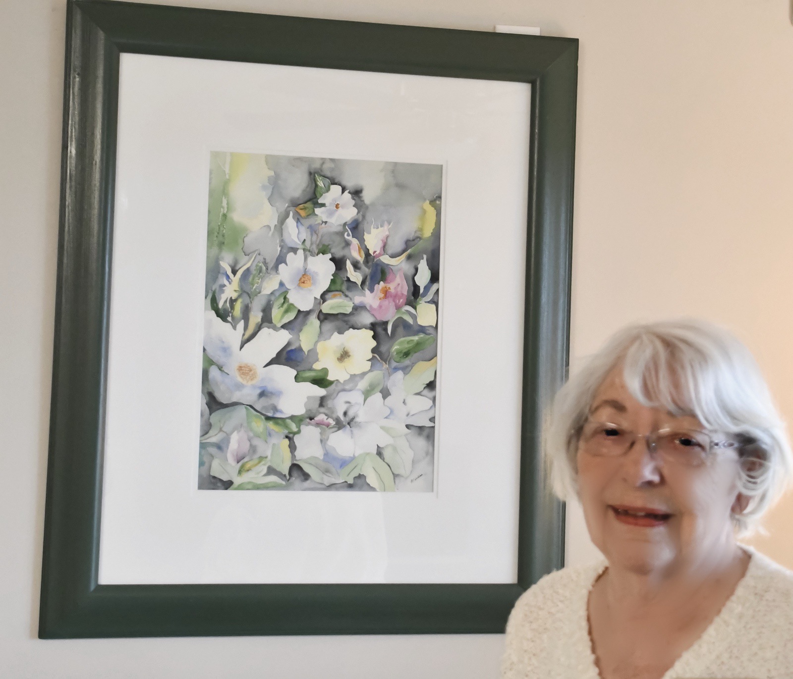 Arlene Terdina poses with her favorite watercolor painting. (Photo by Christine Such/My Sun Day News)