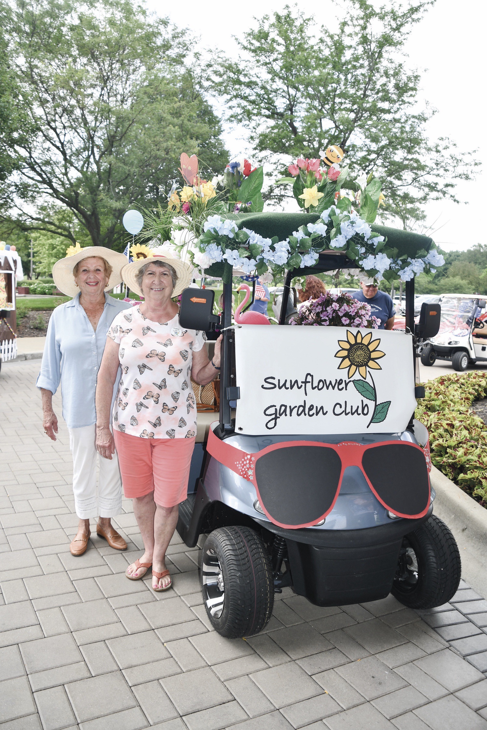 Clubs, residents, and Neighborhoods are invited to decorate their golf carts and join in the upcoming 25th annual Golf Cart Parade, like Garden Club President Paulette Carrion (right) and Judy Perry at a previous parade. (Photo by Christine Such/My Sun Day News)