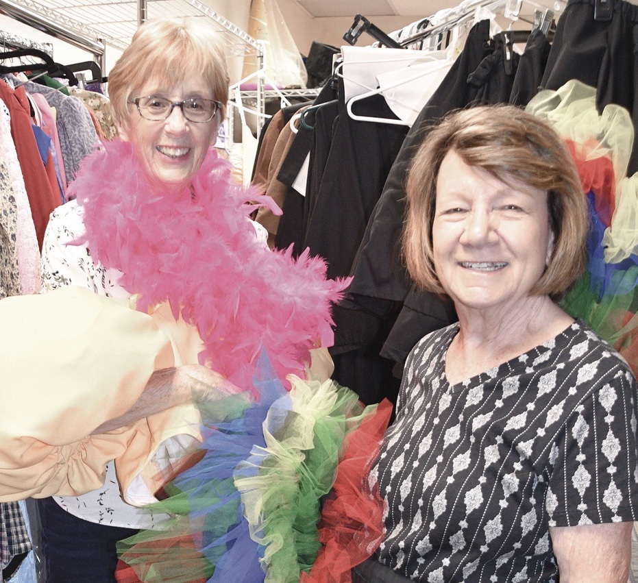 Meet the designing women Donna Scott (L) and Carol Burgett, who creat the costumes for the Sun City Theatre Company’s productions. Here they model some costume pieces off the rack. (Photo by Christine Such/My Sun Day News)