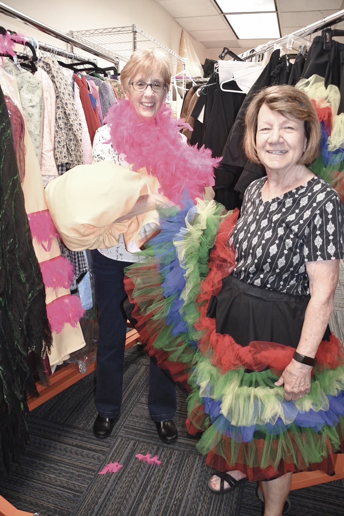 Meet the designing women Donna Scott (L) and Carol Burgett, who creat the costumes for the Sun City Theatre Company’s productions. Here they model some costume pieces off the rack. (Photo by Christine Such/My Sun Day News)